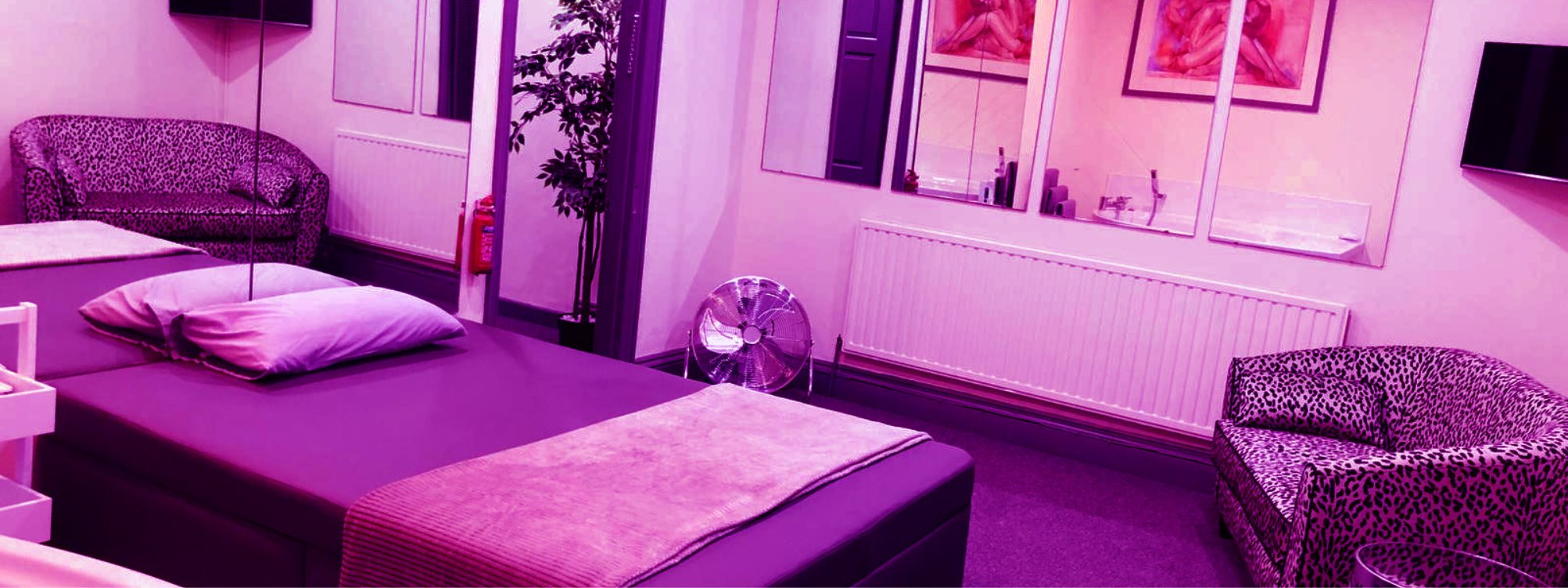 A bedroom with purple lighting